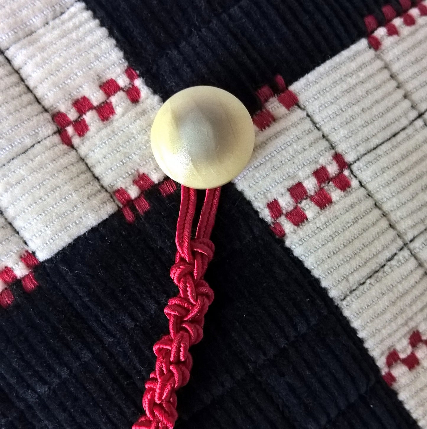 The smoking cap is finished with an unusual vintage button in cream
