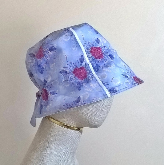 Cotton silk bucket hat with raspberries and lavender on a blue background, and adjustable tie back