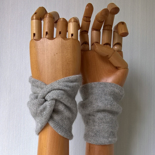 Light gray cashmere wrist warmers in a snug knot design