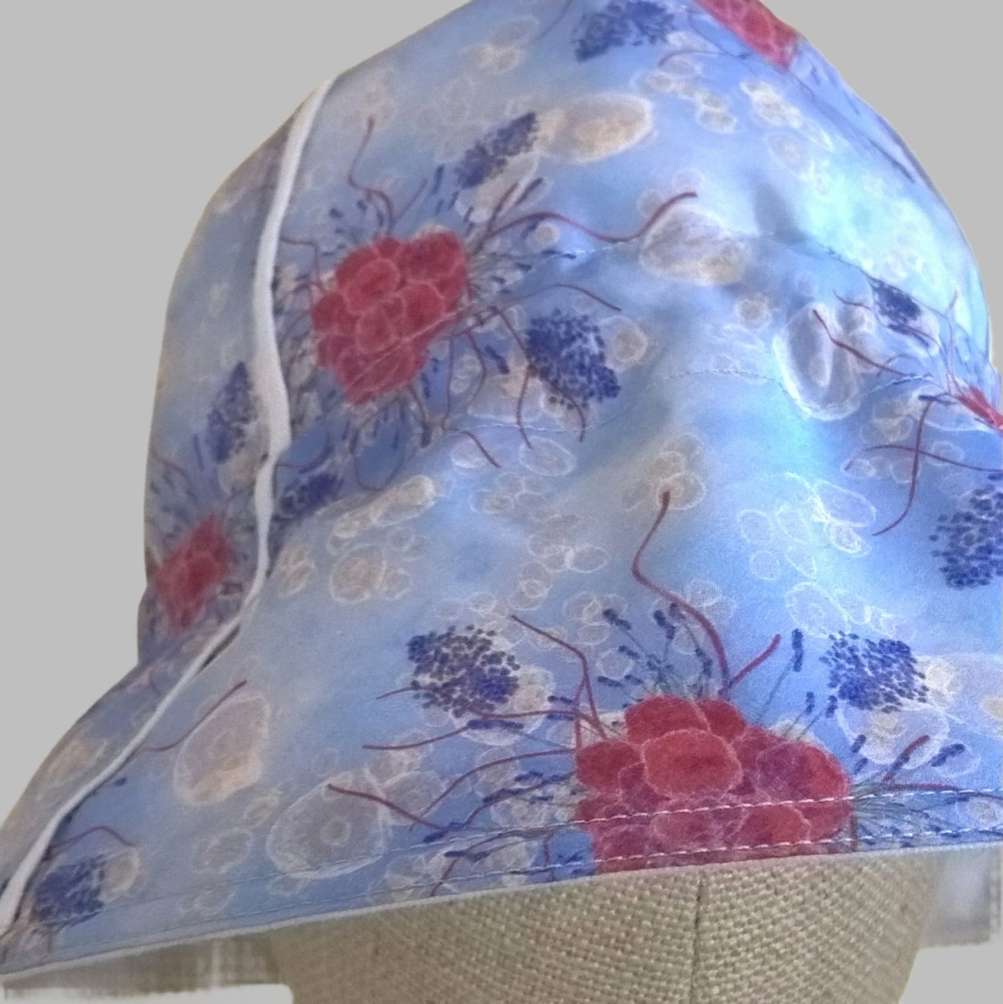 Raspberries and lavender on a blue background is the floral design for this cotton silk handmade bucket hat
