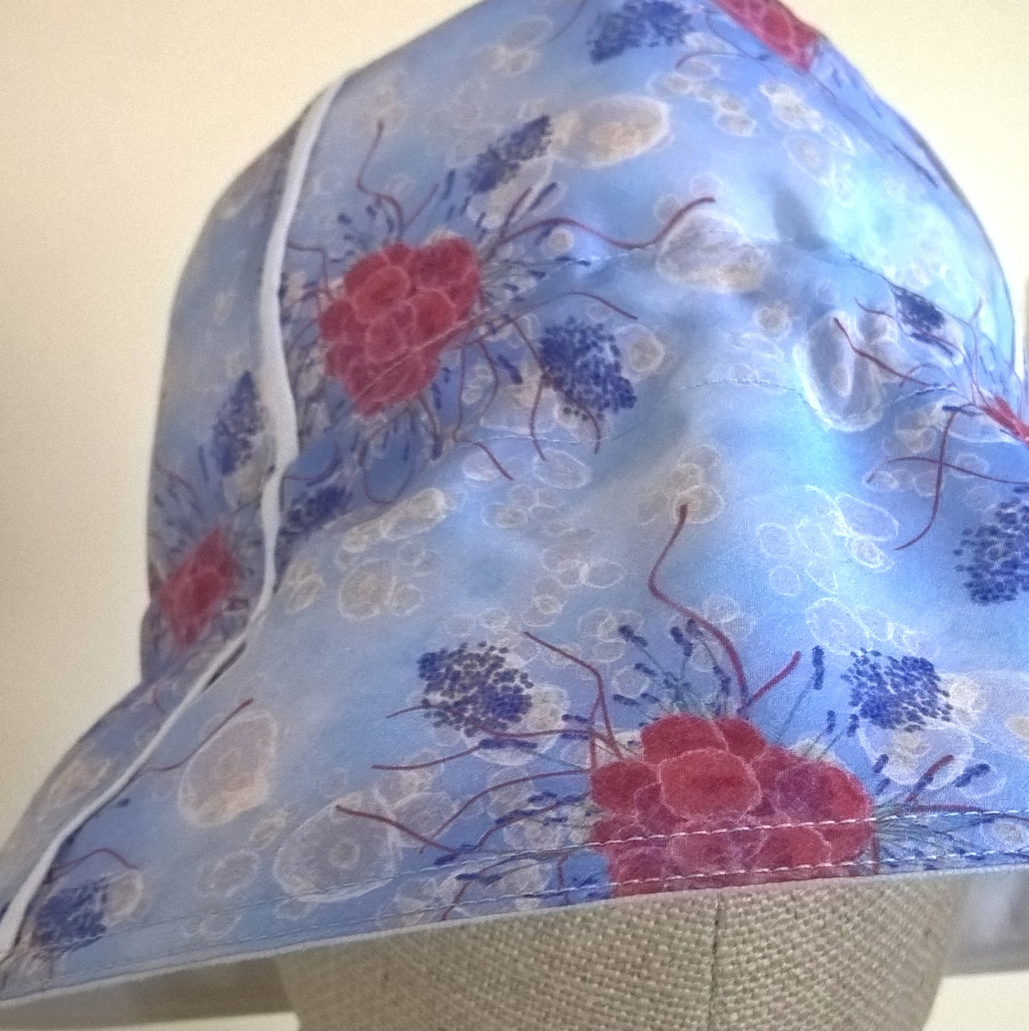 Raspberries and lavender on a blue background is the floral design for this cotton silk handmade bucket hat