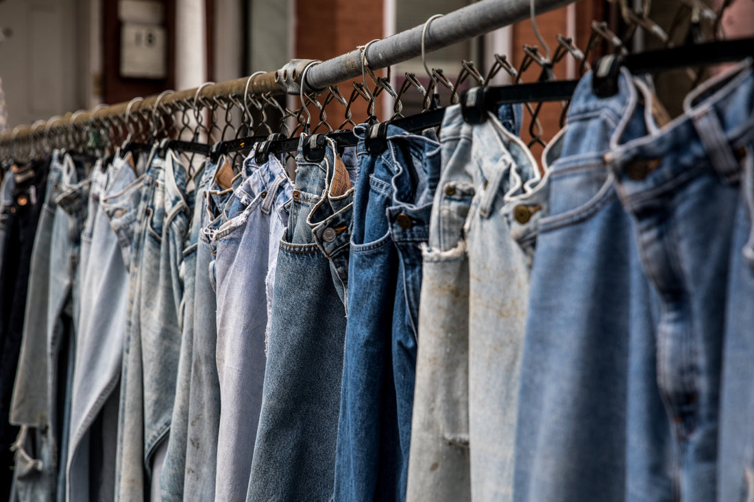 Various washes of vintage denim jeans hanging on a rail are recycled at TwiLd Capit Ho