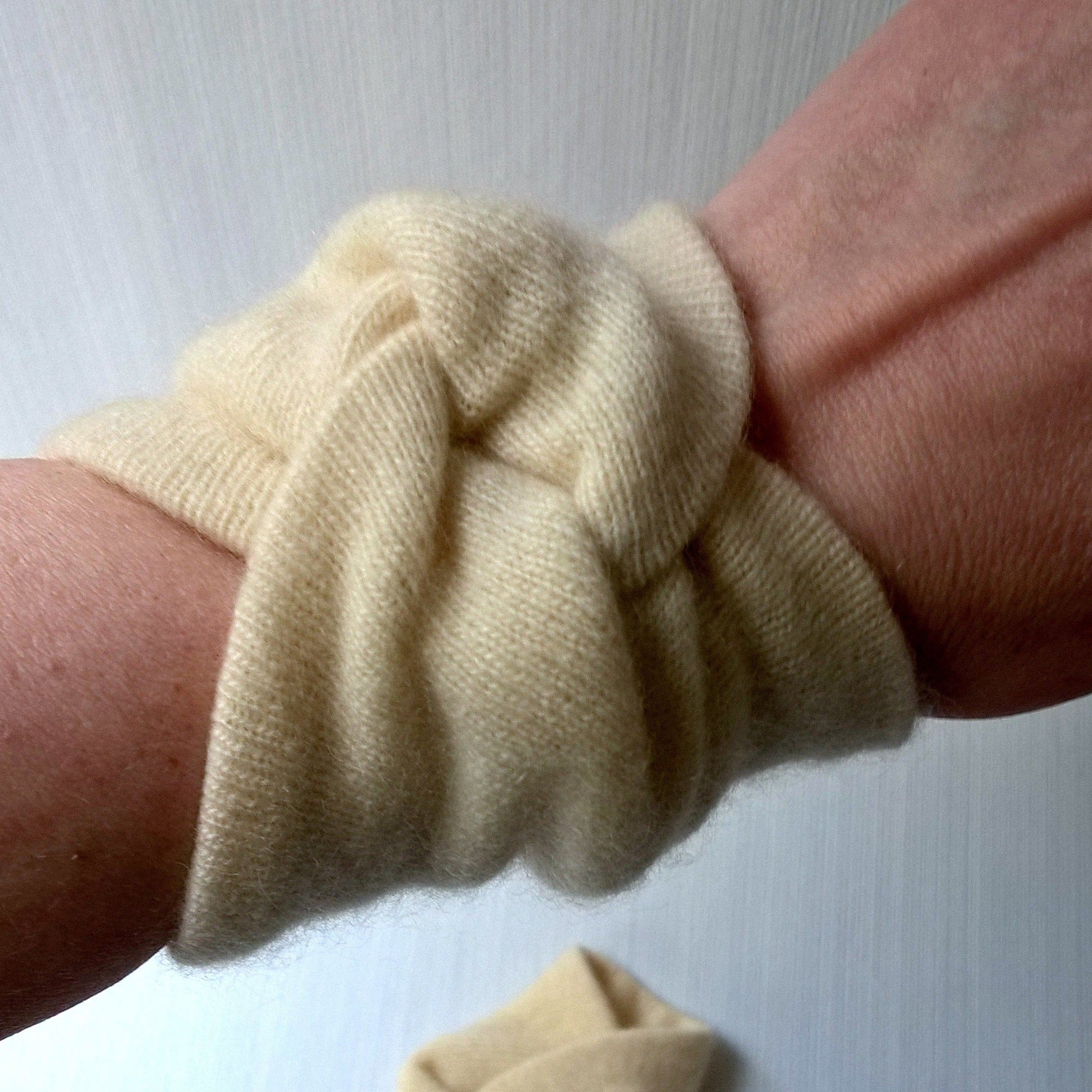 Cream coloured pure cashmere wrist warmers  being worn