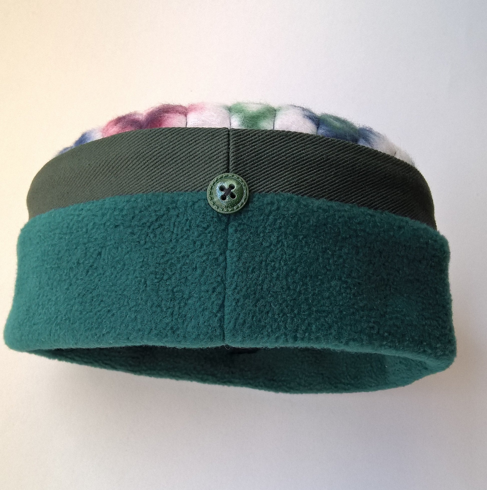 Back button detail of green fleece and Aztec patterned pillbox hat