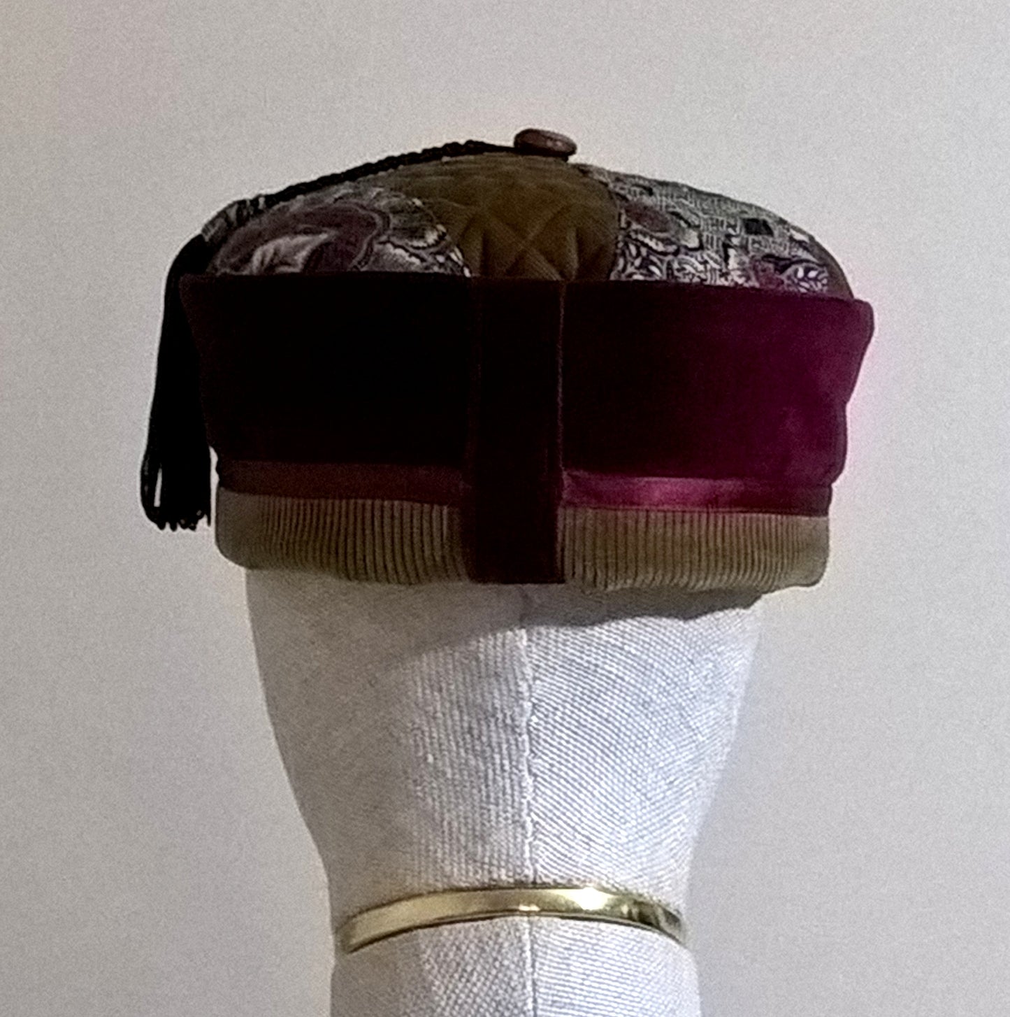 Back view of burgundy velvet and olive brown paisley thinking cap with tassel