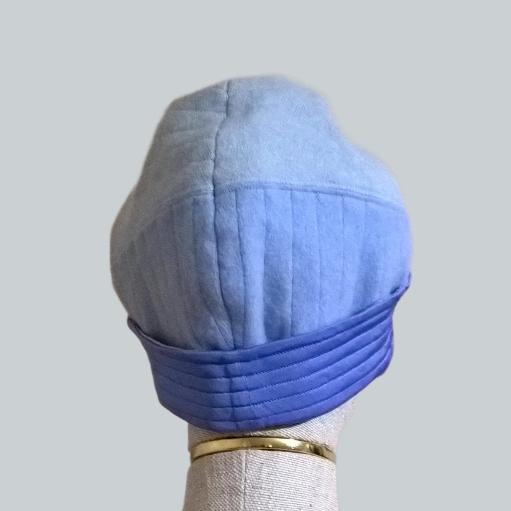 Back view of up-cycled cashmere patchwork beanie hat with silk jersey cuff in shades of blue