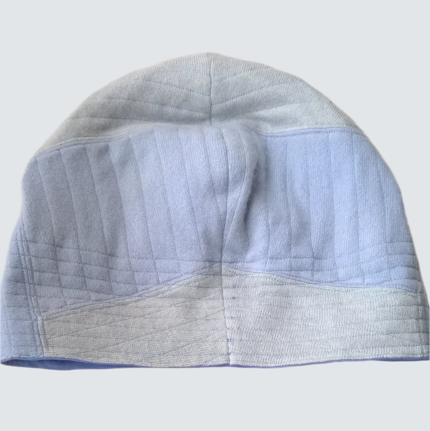 Back of cashmere beanie hat with silk cuff rolled down to show patchwork design