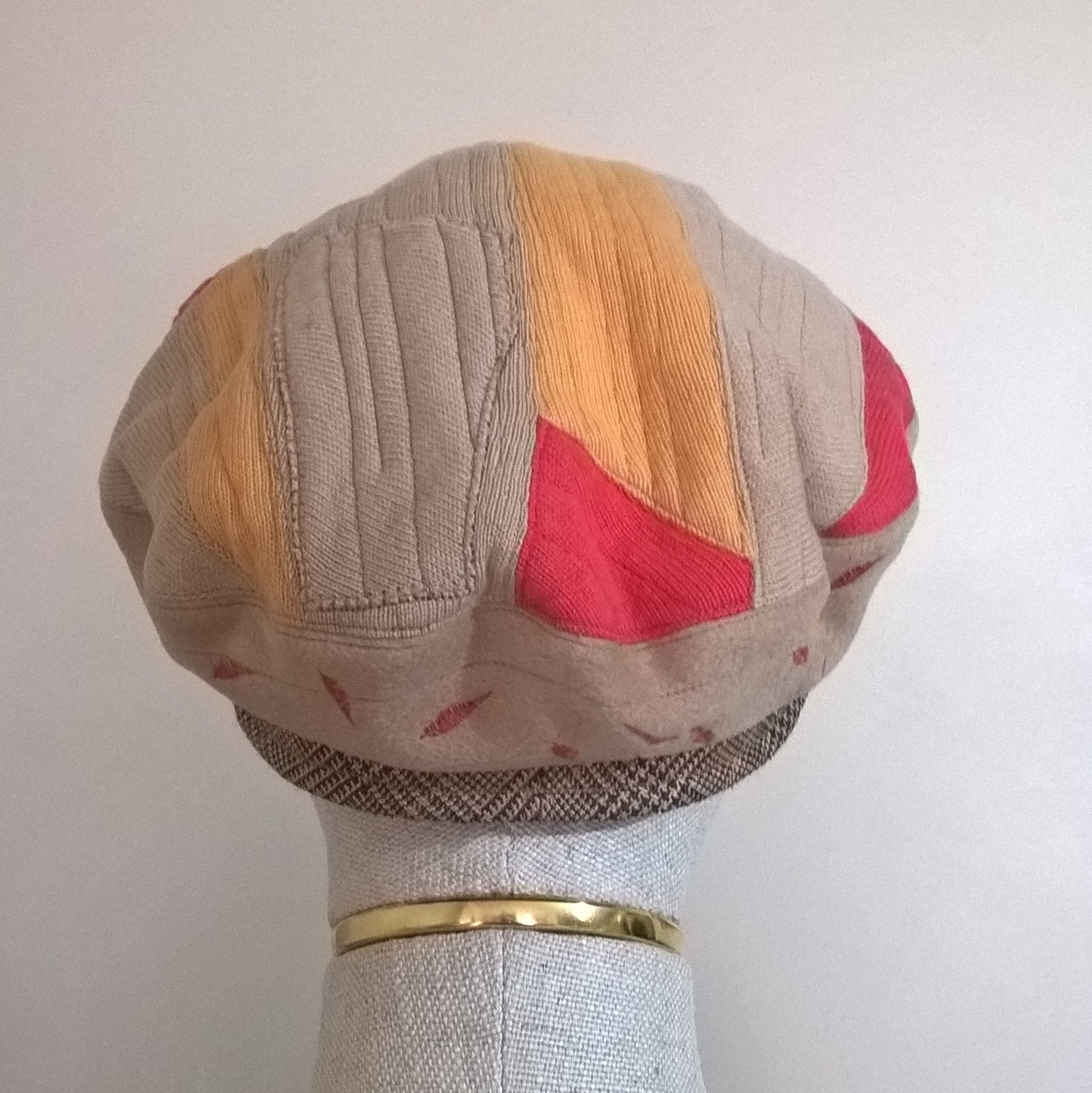 Back view of quilted patchwork beret in fawn, red and yellow