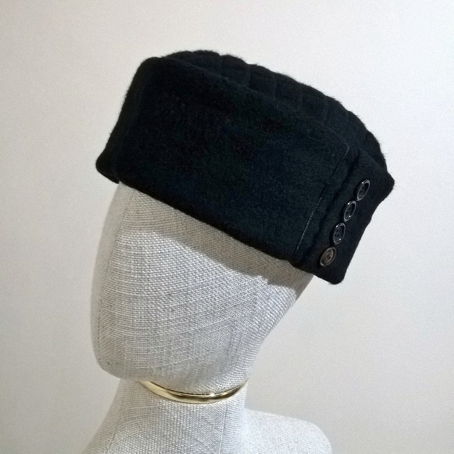 Black cashmere pillbox cap with button detail on crown