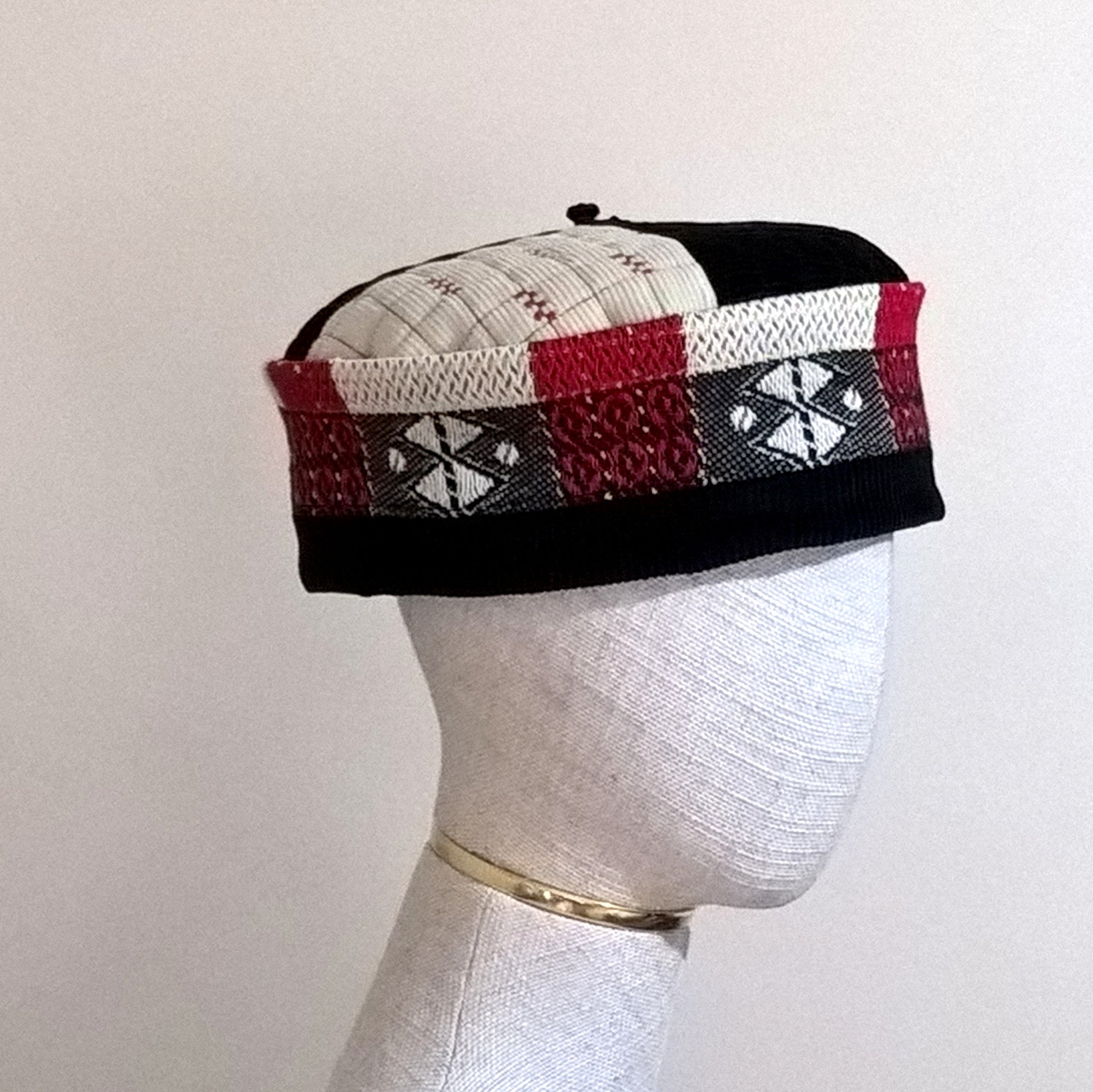 Corduroy pillbox shaped smoking cap in vibrant black, red and cream with removable tassel