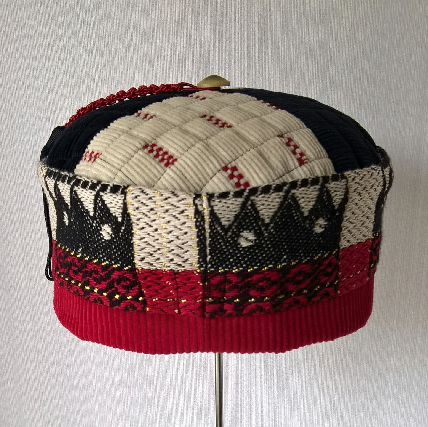 Back view of smoking cap in black, red and cream