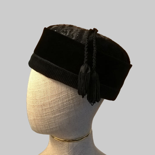 Black velvet and felted Smoking Cap with two macrame tassels on a mannequin head