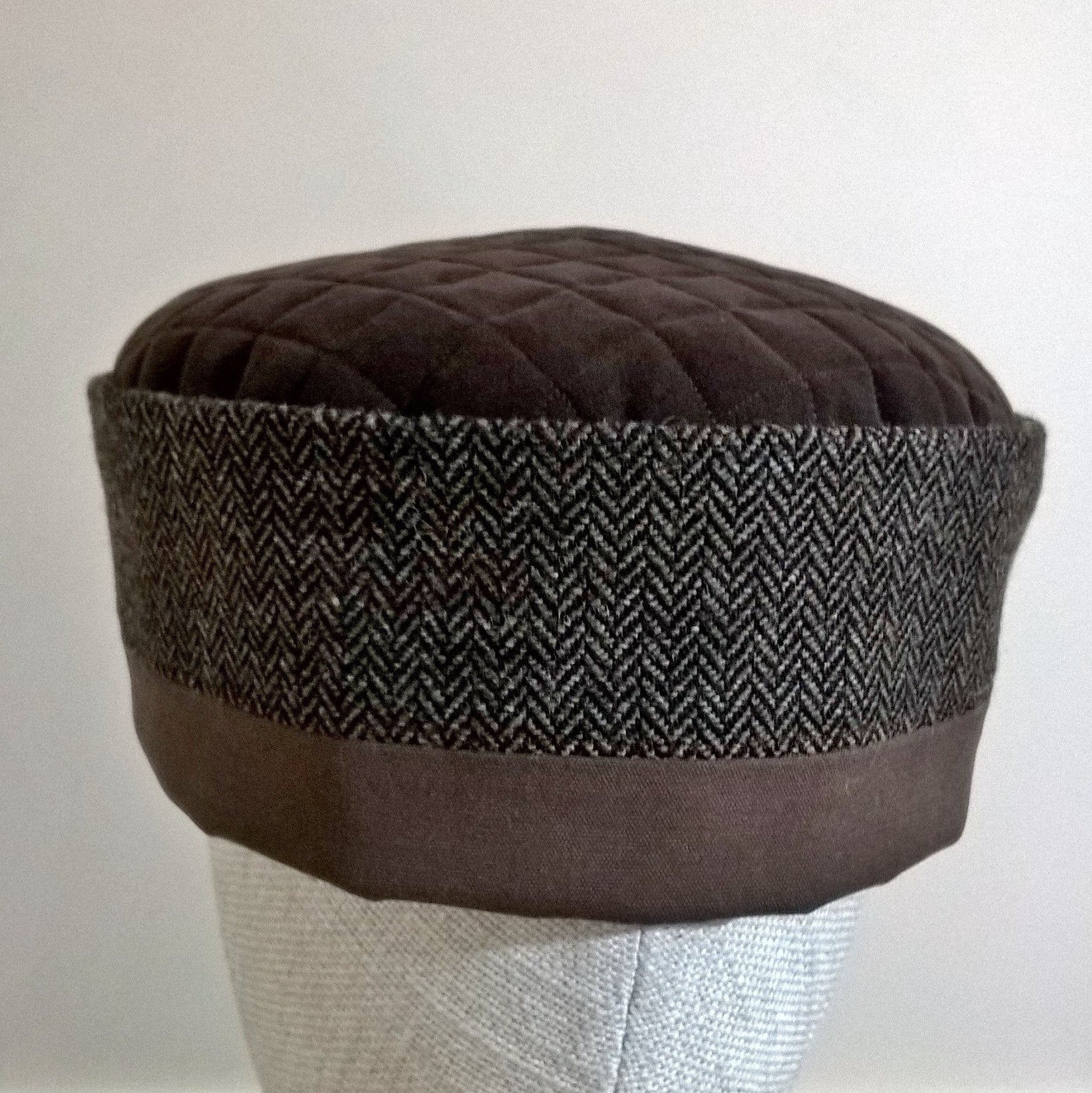 The pillbox hat has a quilted tip and herringbone wool crown
