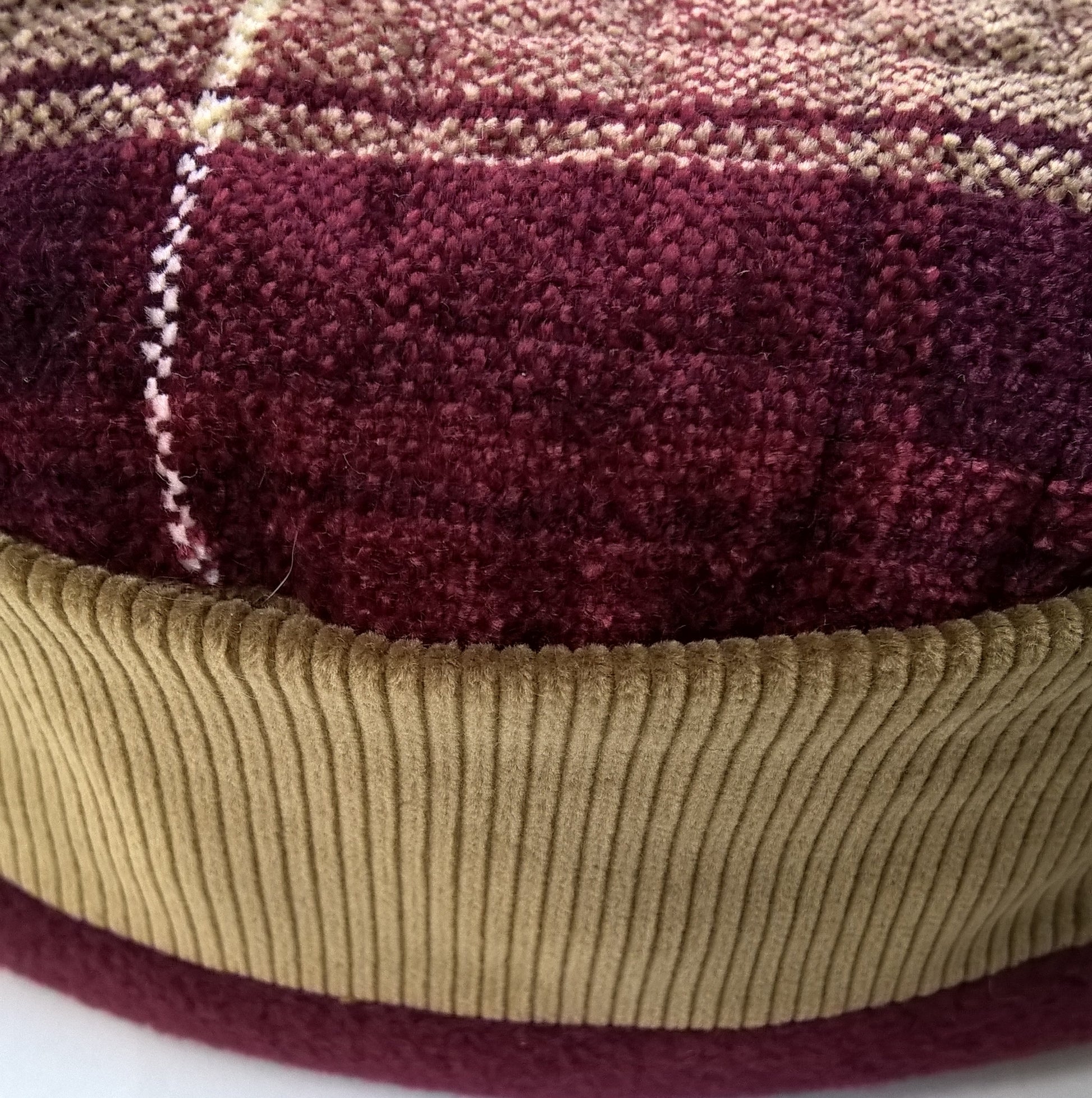 The hat has a chenille tip and olive green corduroy crown trimmed with burgundy fleece. 