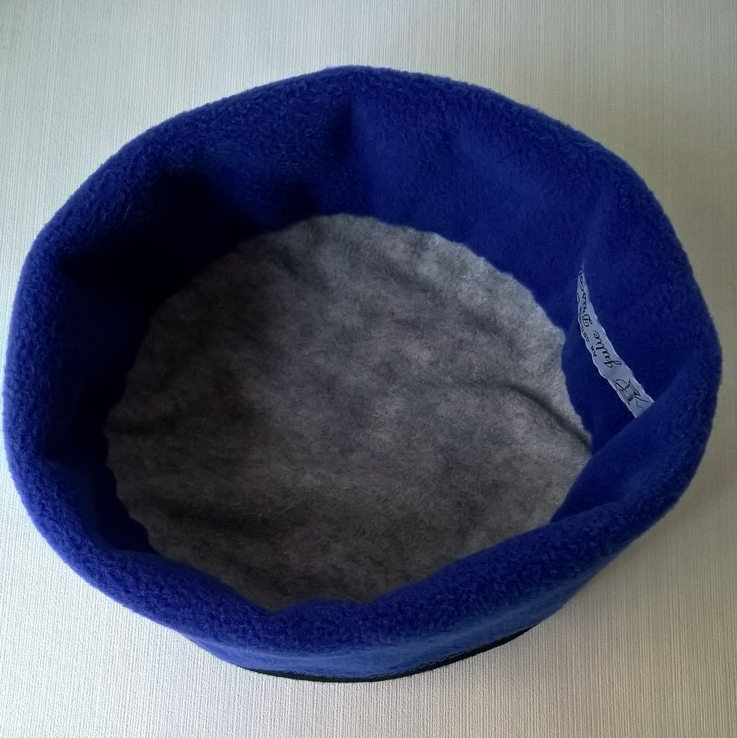 The cobalt blue hat has a grey fleece lining