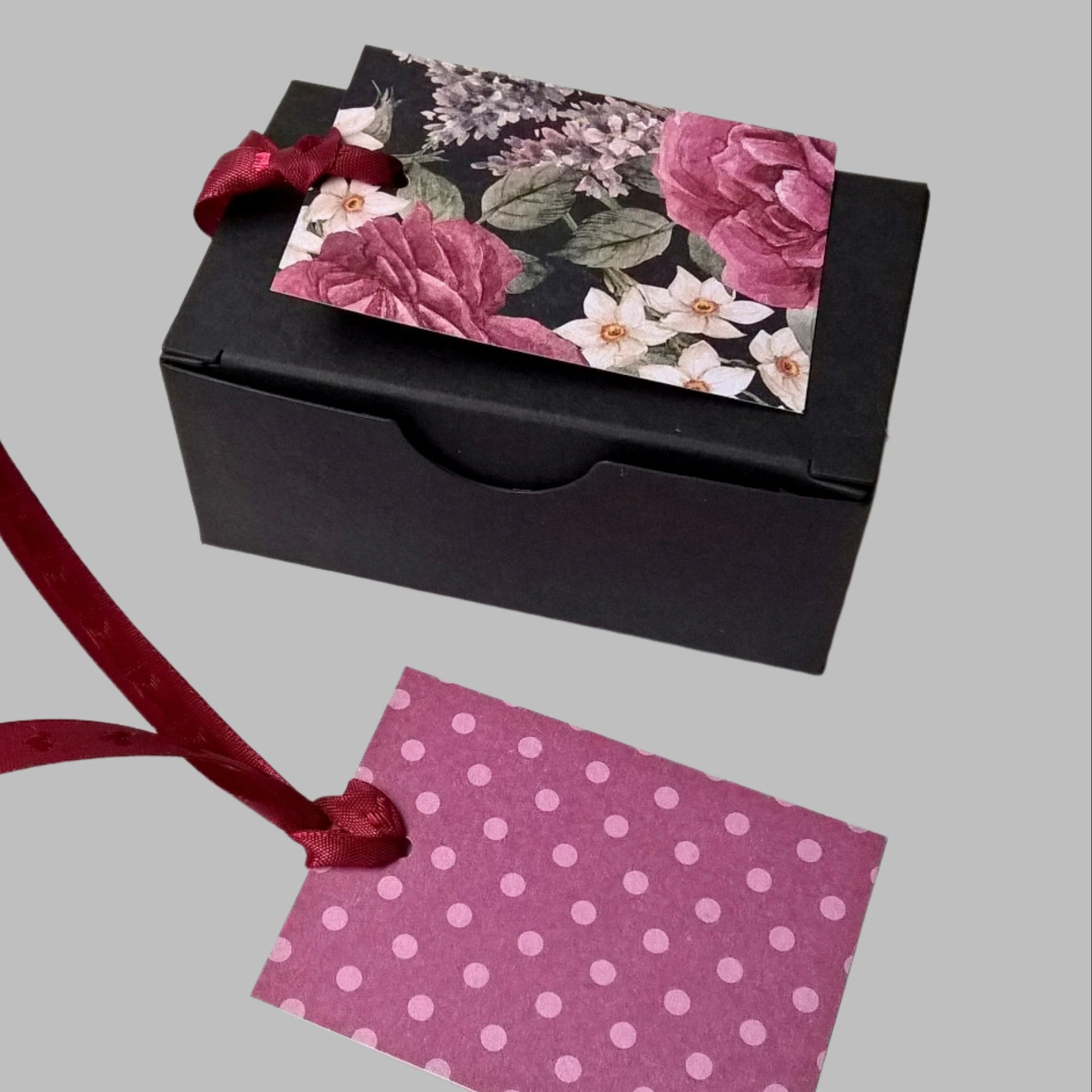 The gift box comes with a floral gift card on burgundy heart ribbon