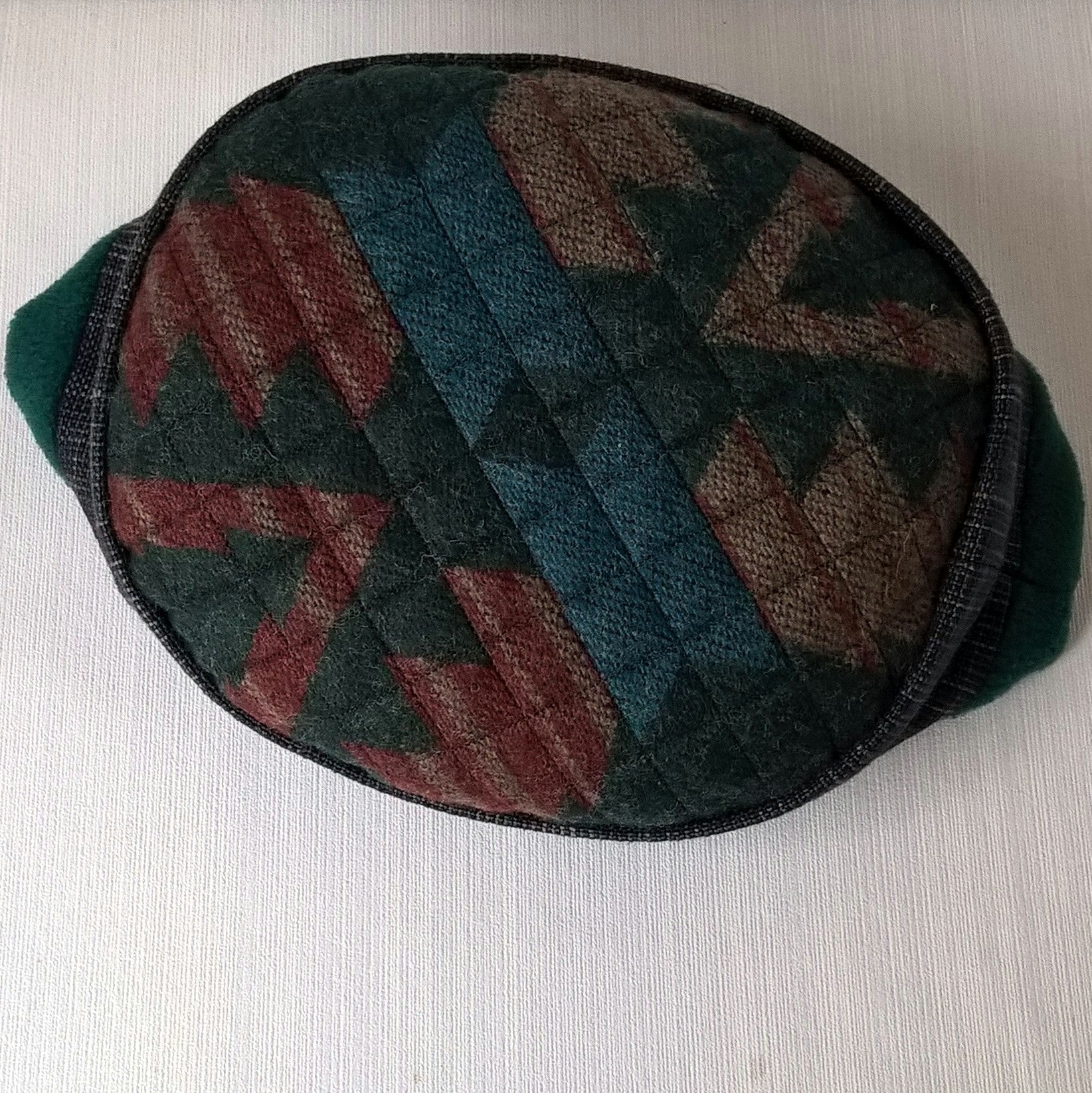 Aztec pattern on tip of forest green brimless cap