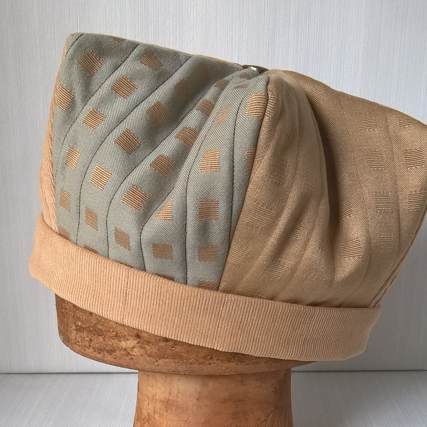 The crown shaped hat features a harlequin style square pattern