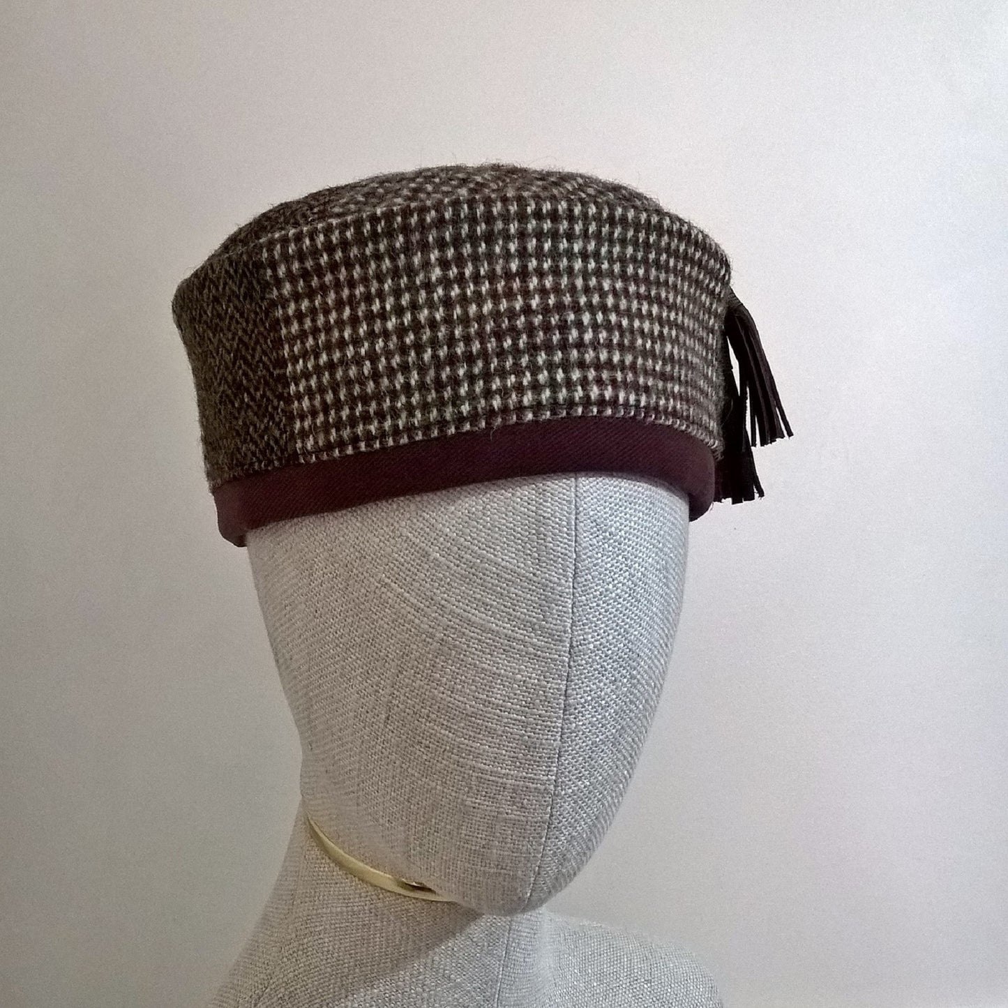 Harris Tweed wool smoking cap, in browns, cream and mauve shades, with leather tassel