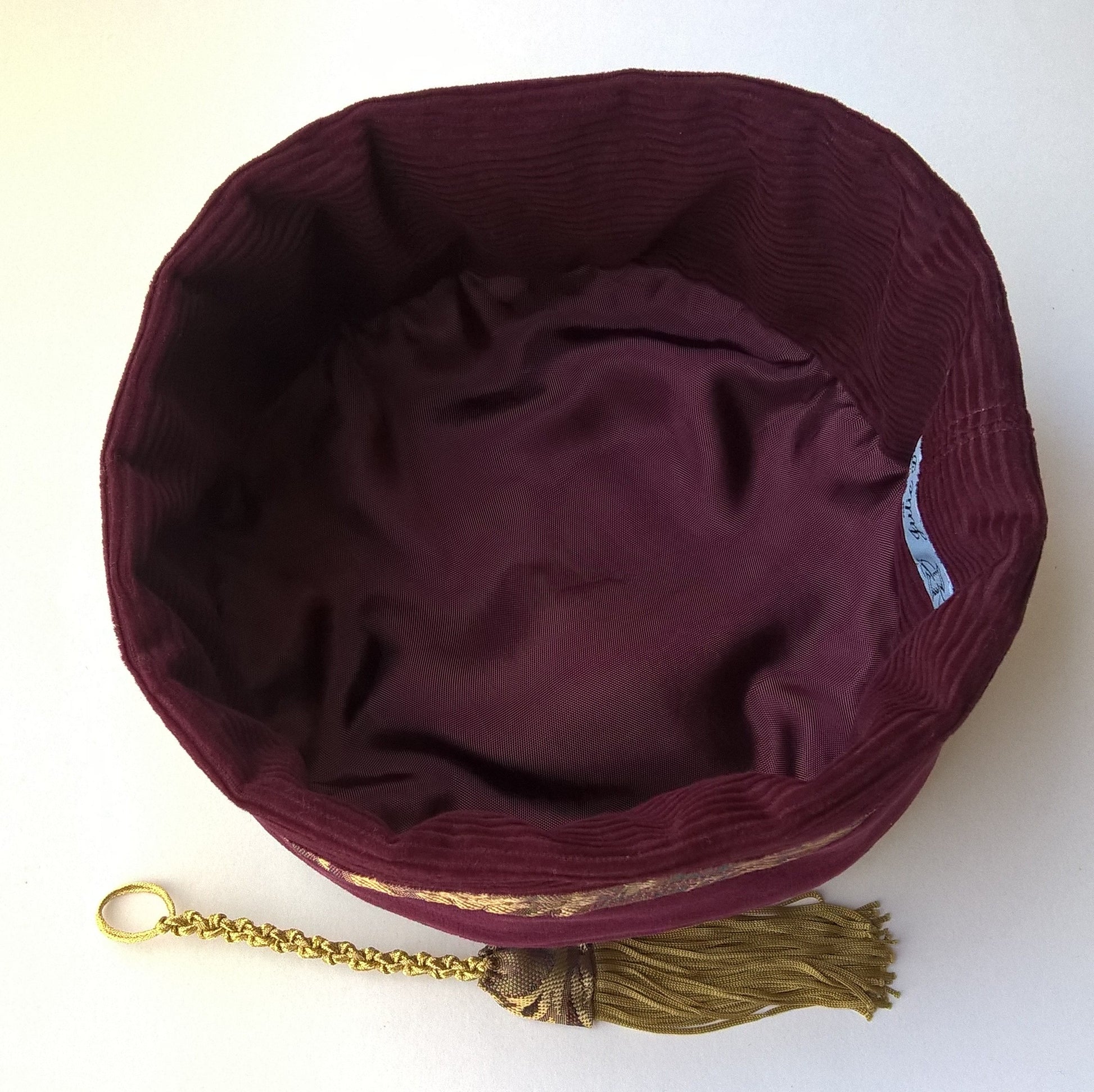 The hat is lined with wine coloured cotton corduroy and rayon