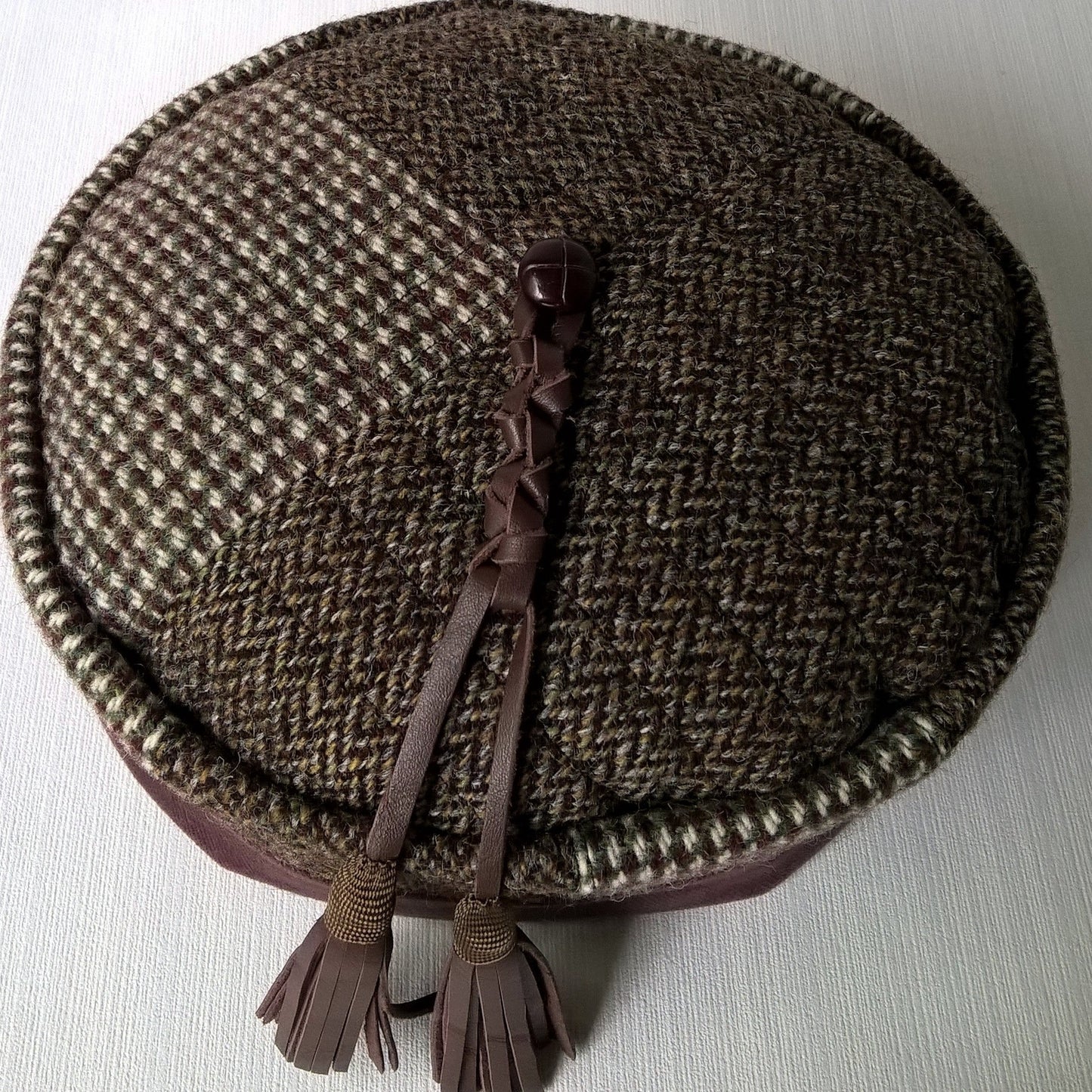 A unique smoking cap with mismatched vintage Harris Tweed wool and leather tassel in a macrame design