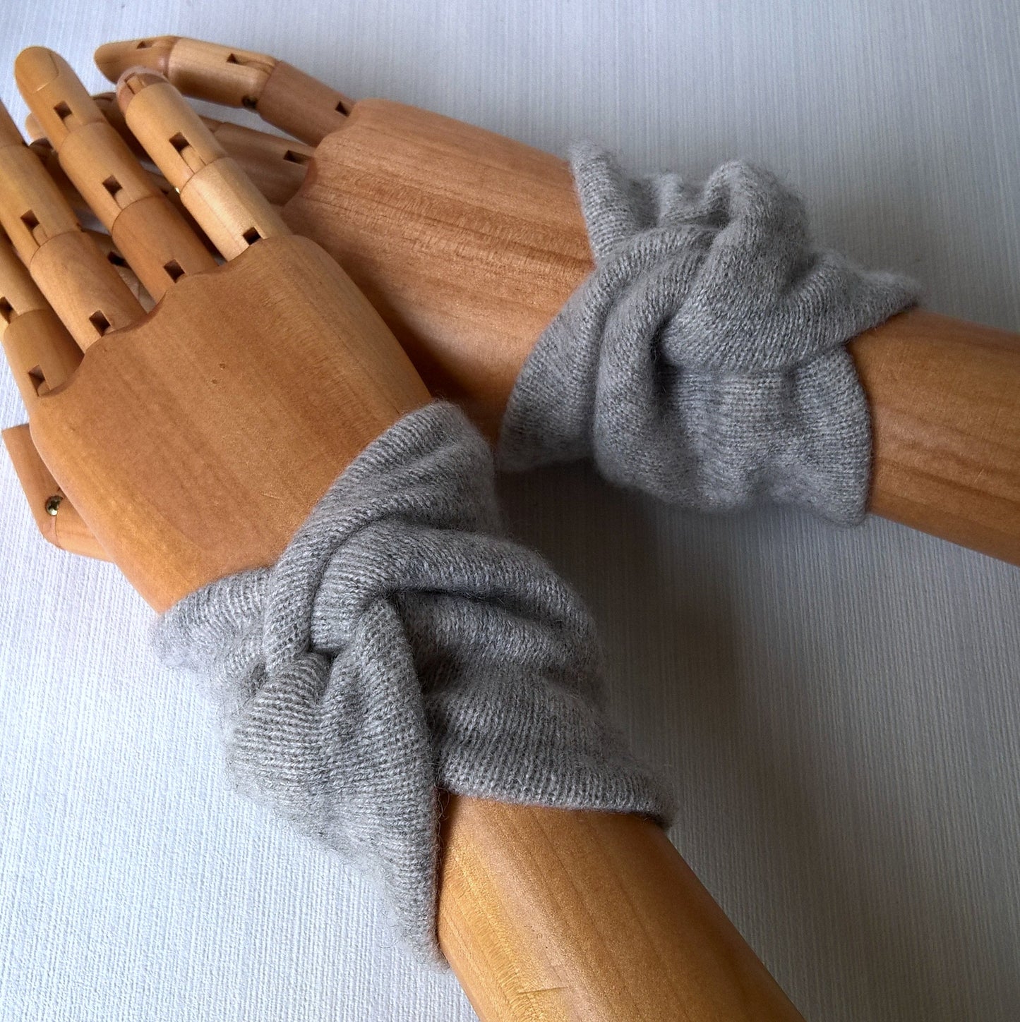 A pair of handmade light grey marl upcycled cashmere wrist warmers