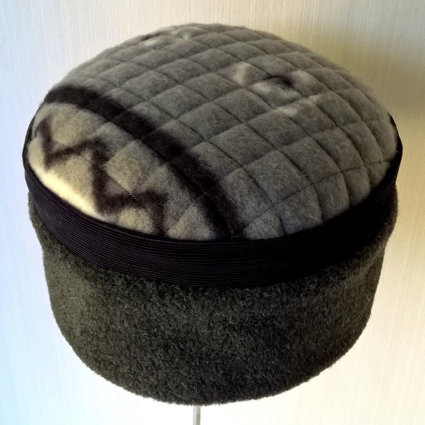 Grey fleece pillbox shaped hat with quilted tip