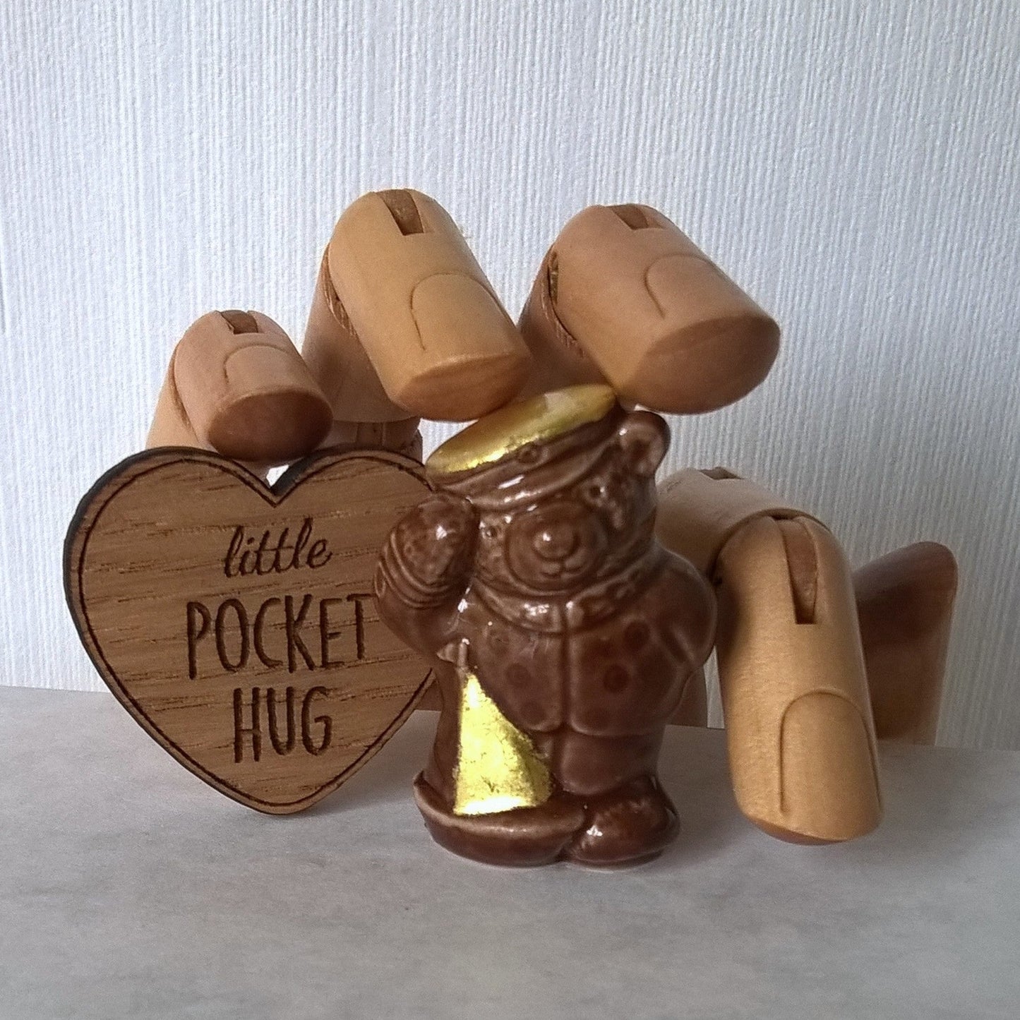 Little brown ceramic sailor bear with wooden heart pocket hug . Pure gold leaf has been added to the bears cap and sail of boat