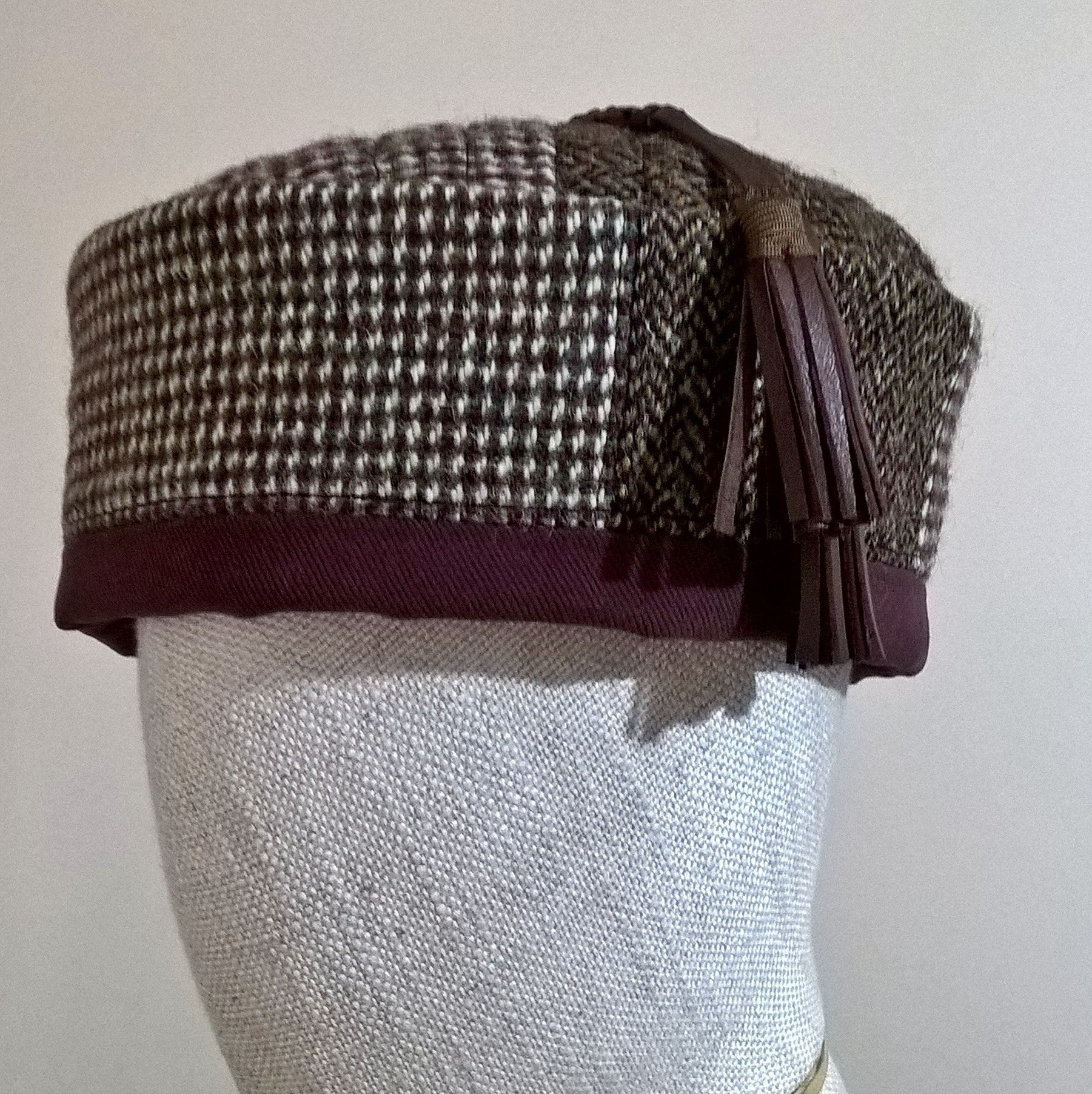 Close up of Harris Tweed and leather tassel of pillbox hat