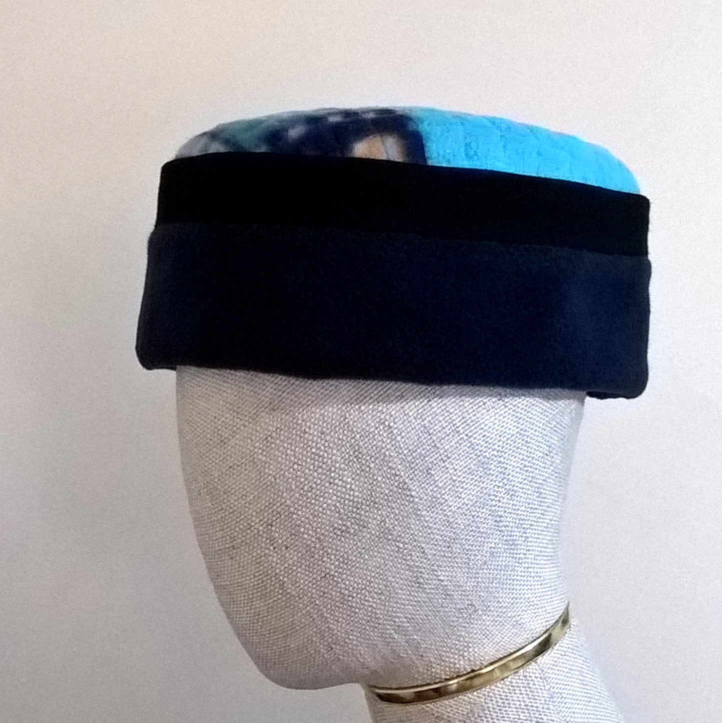 Navy and turquoise pillbox fleece cap with multi coloured patchwork tip