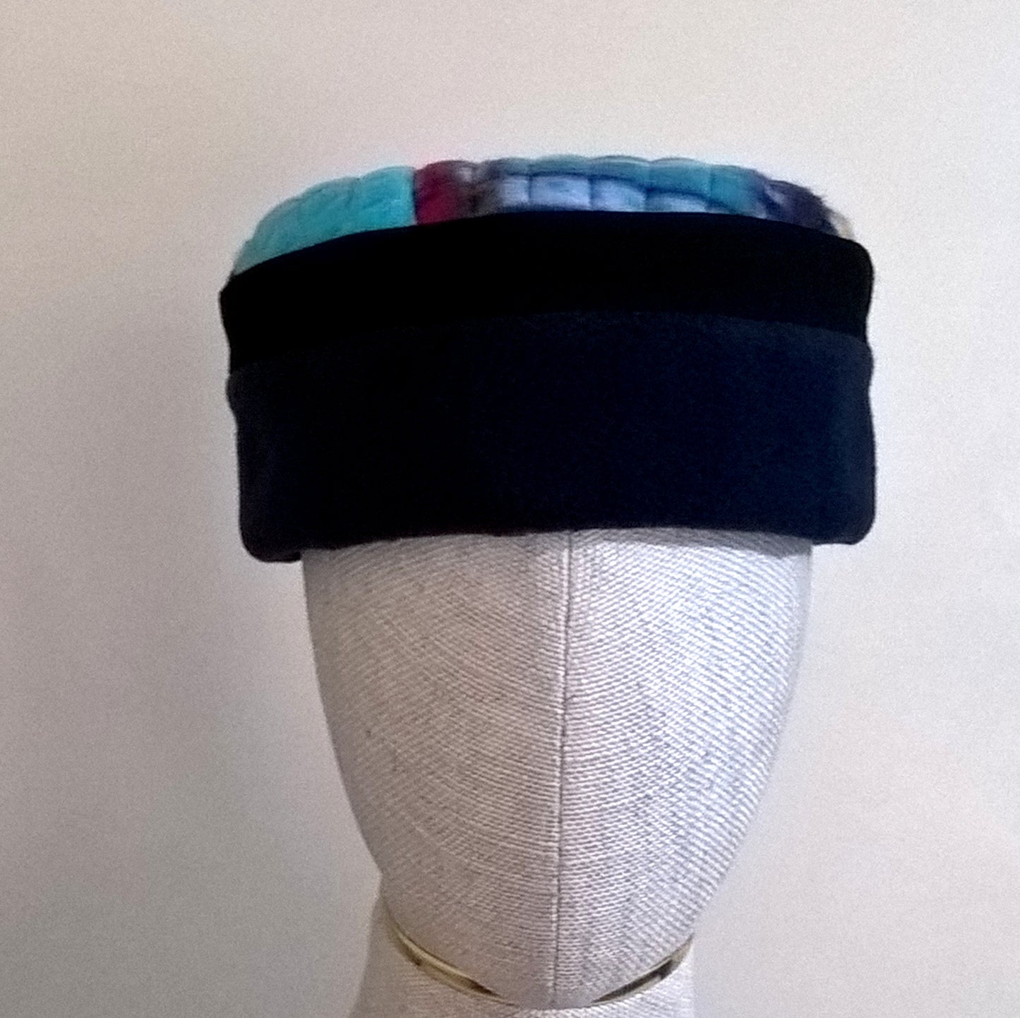 Fleece pillbox cap with a navy crown edged with black and a tribal multi coloured tip