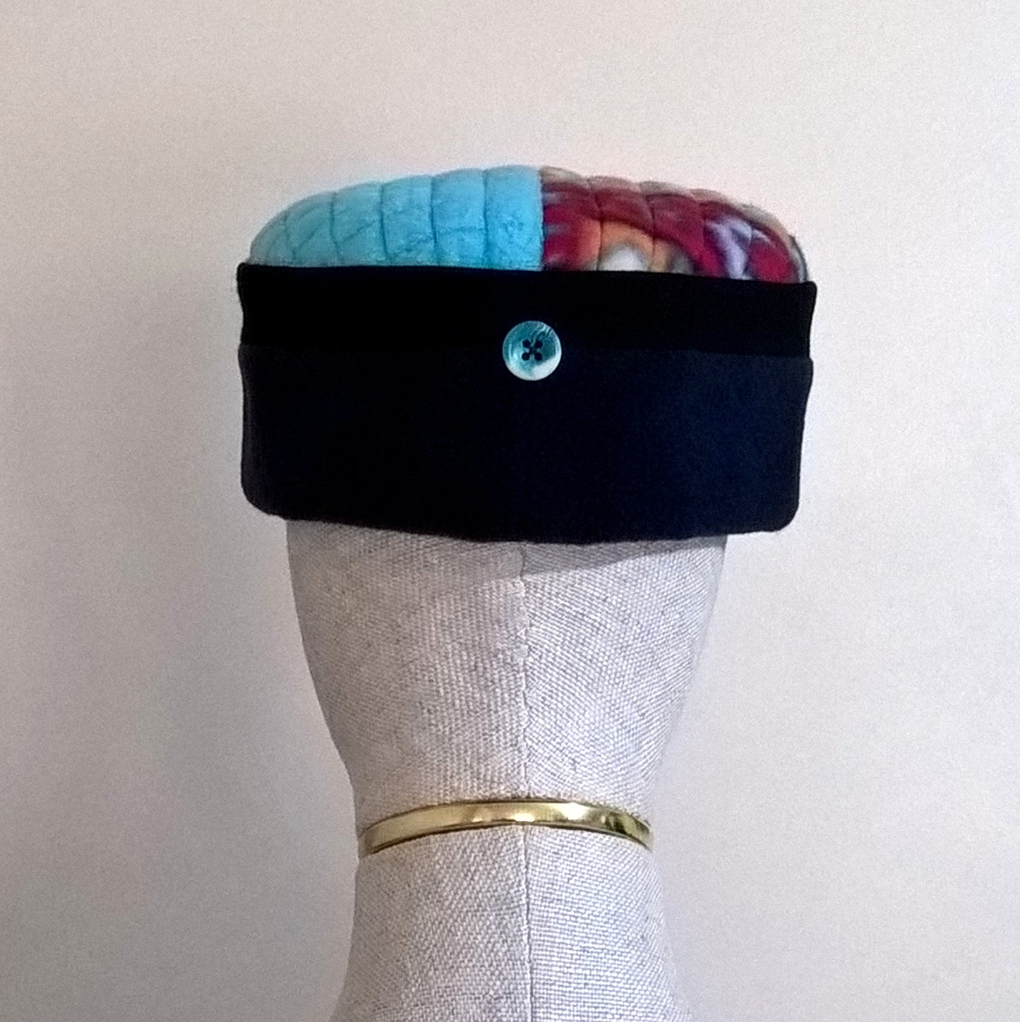 Fleece hat has button detail at centre back which echos the turquoise of the tip.