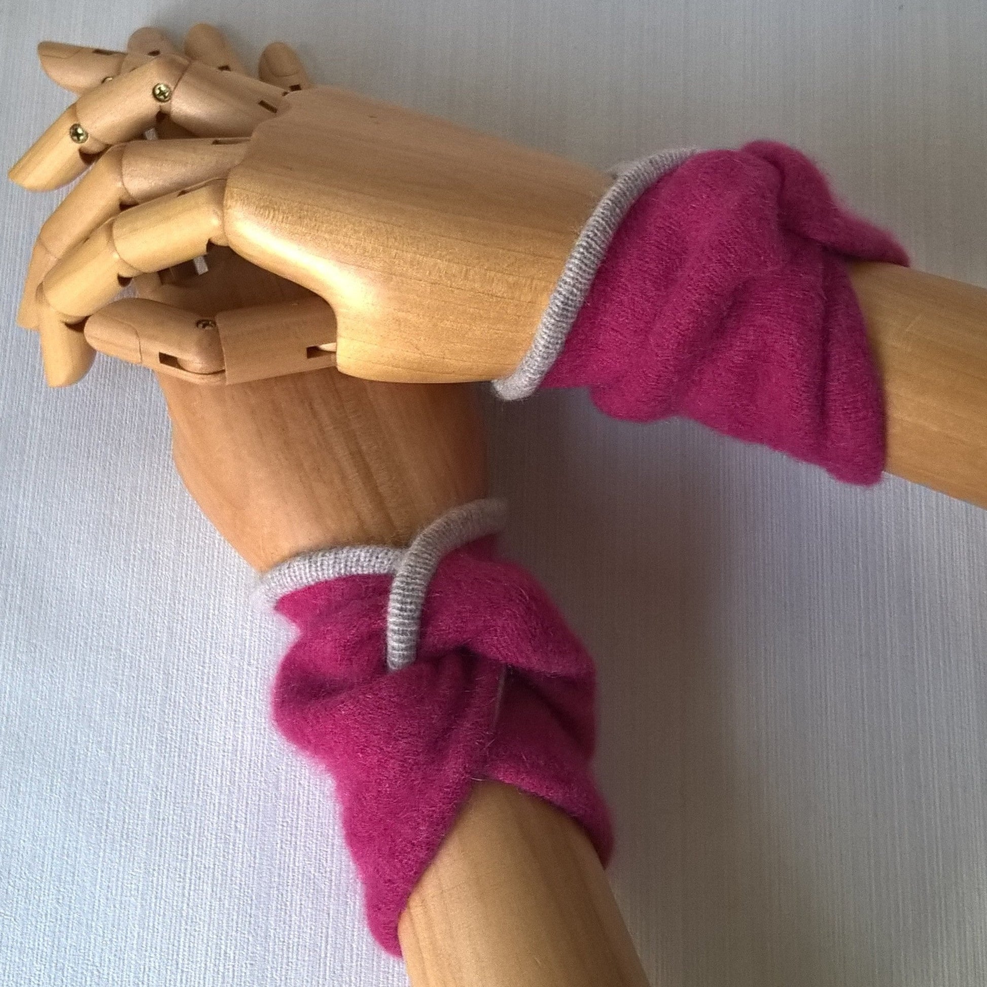 Raspberry pink wrist warmers in a twisted knot design
