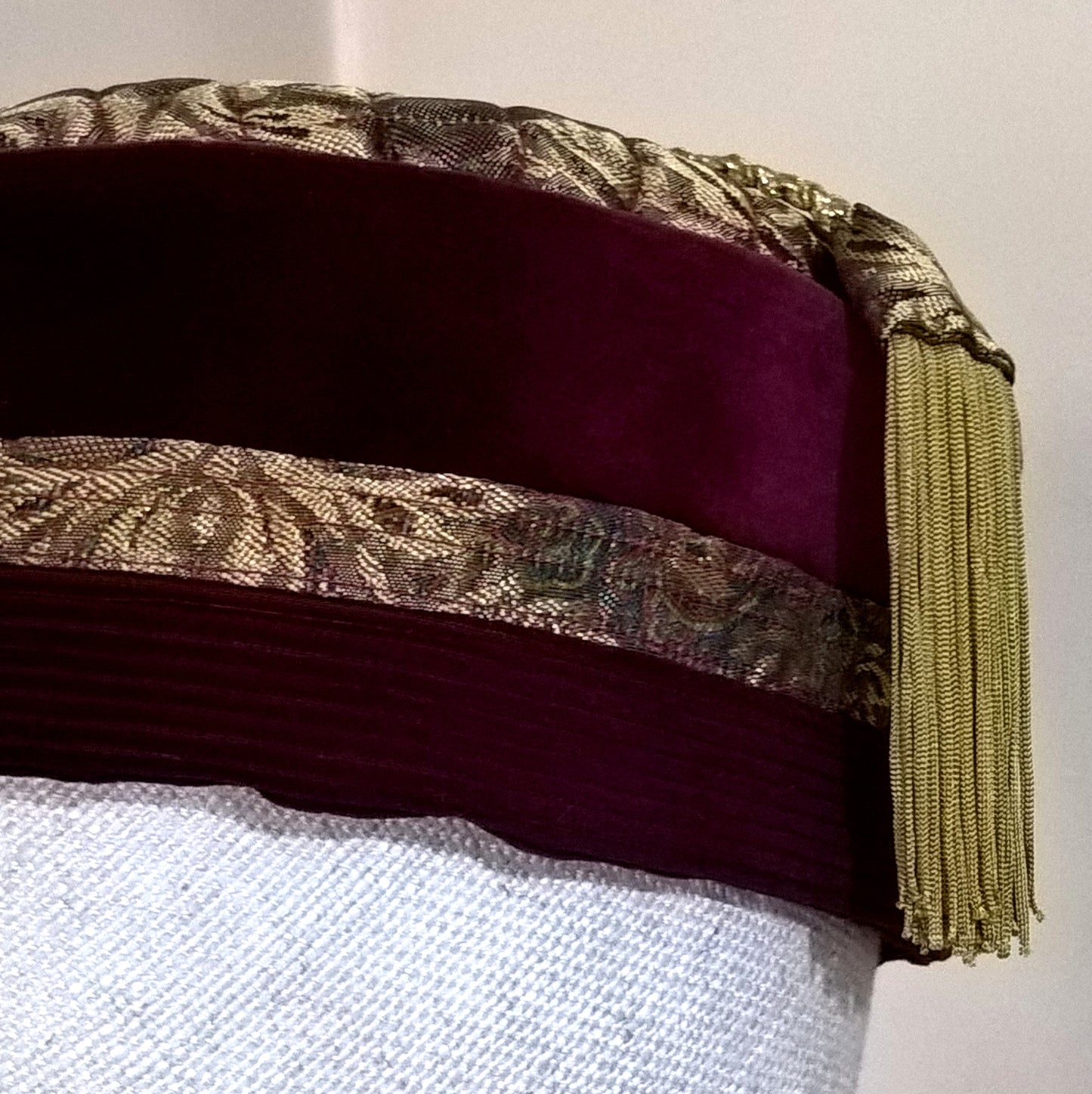 The gold brocade smoking cap is trimmed with wine coloured velvet and corduroy