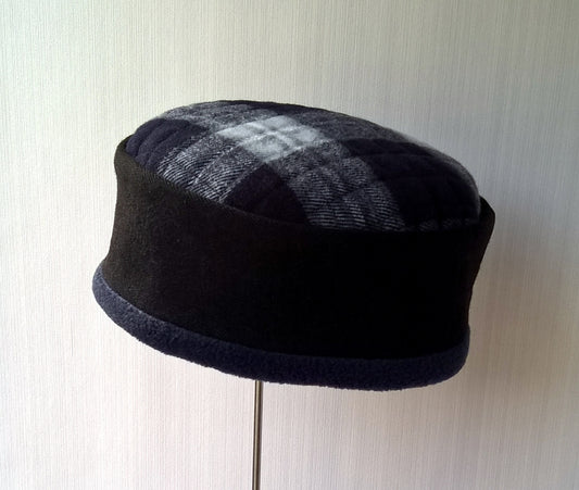 black and navy pillbox shaped winter hat with lumberjack checked tip