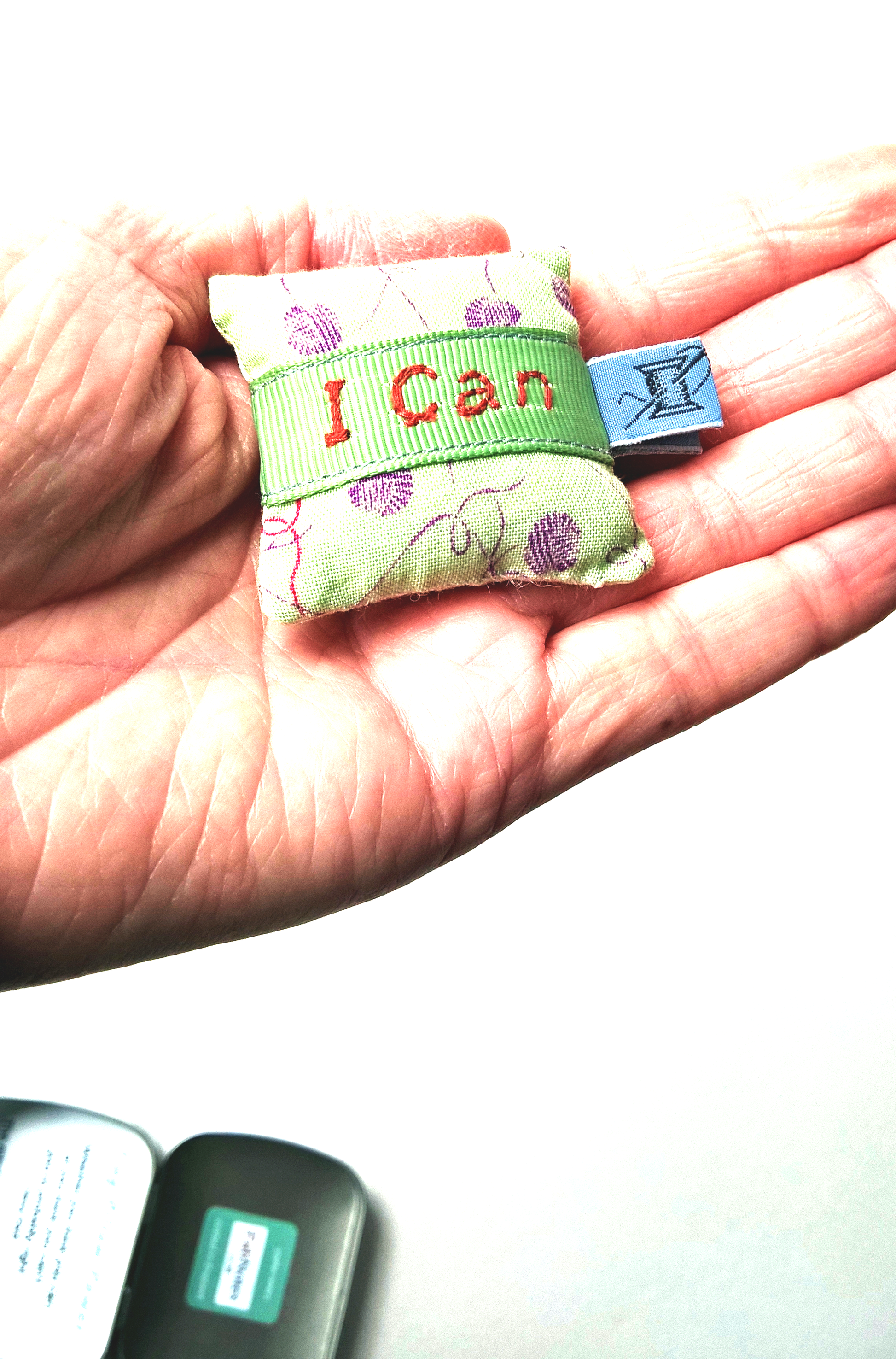 Tiny empowerment pillow shown in the palm of the hand 