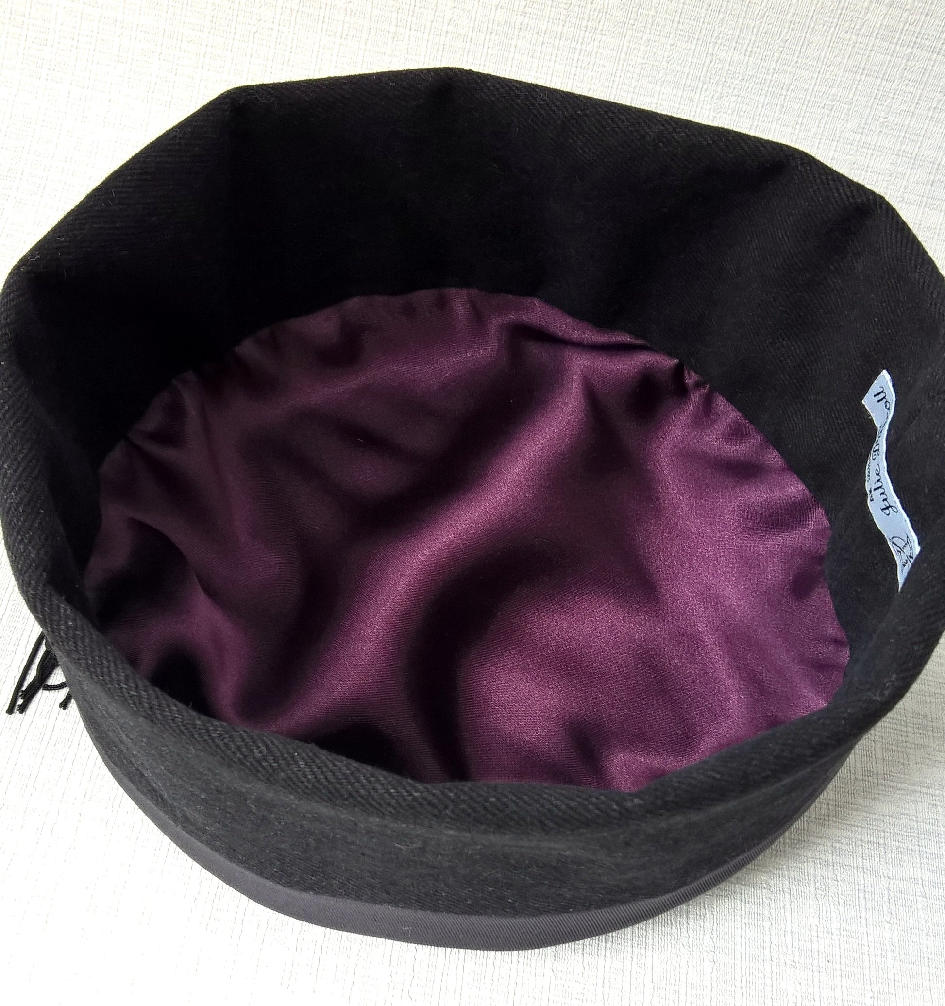 The interior of the smoking cap is hand-finished with an aubergine satin lining