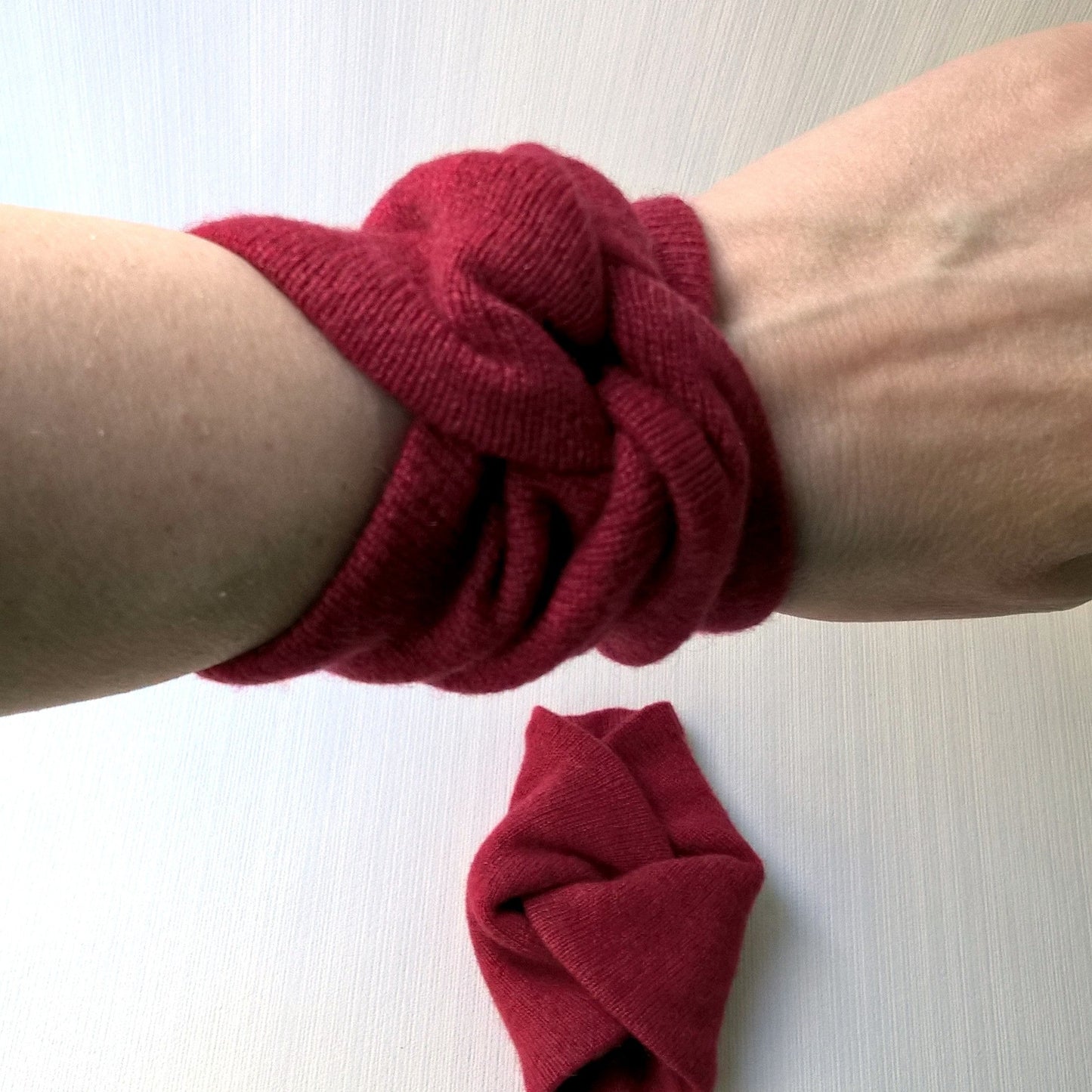 Ruby red pure cashmere wrist warmers in a short wrist knot design