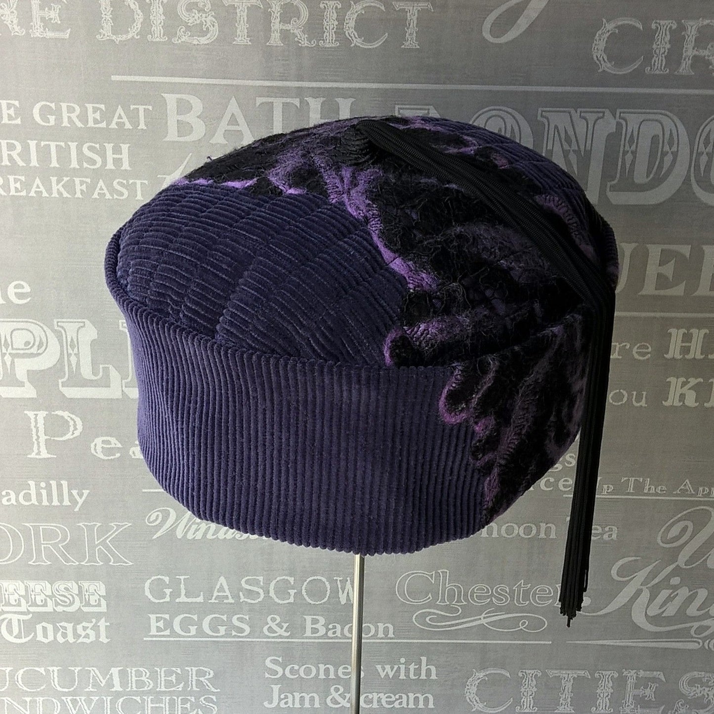 Front of smoking cap in purple corduroy with black and purple felted detail