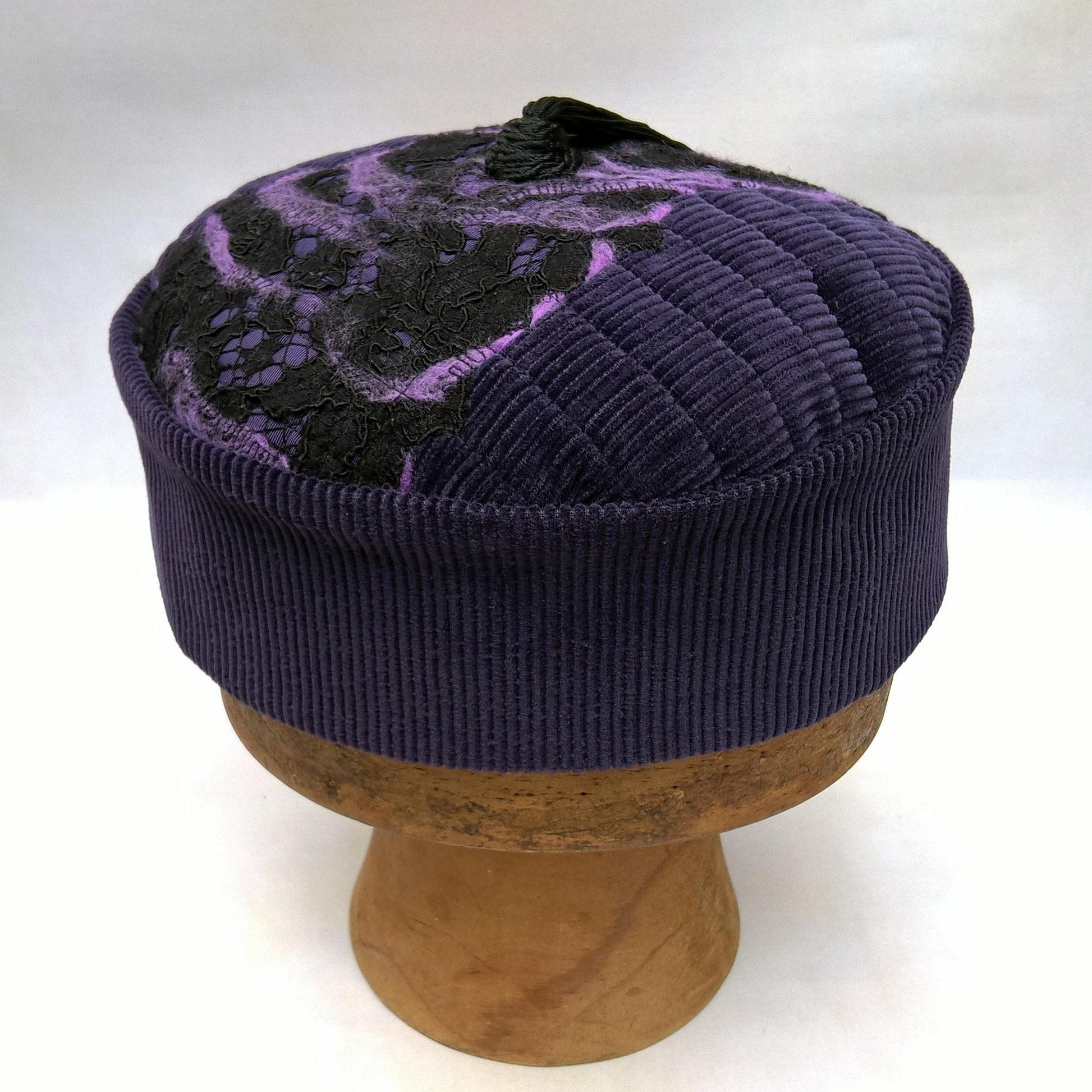 Side view of purple smoking cap with nuno felting and long black tassel
