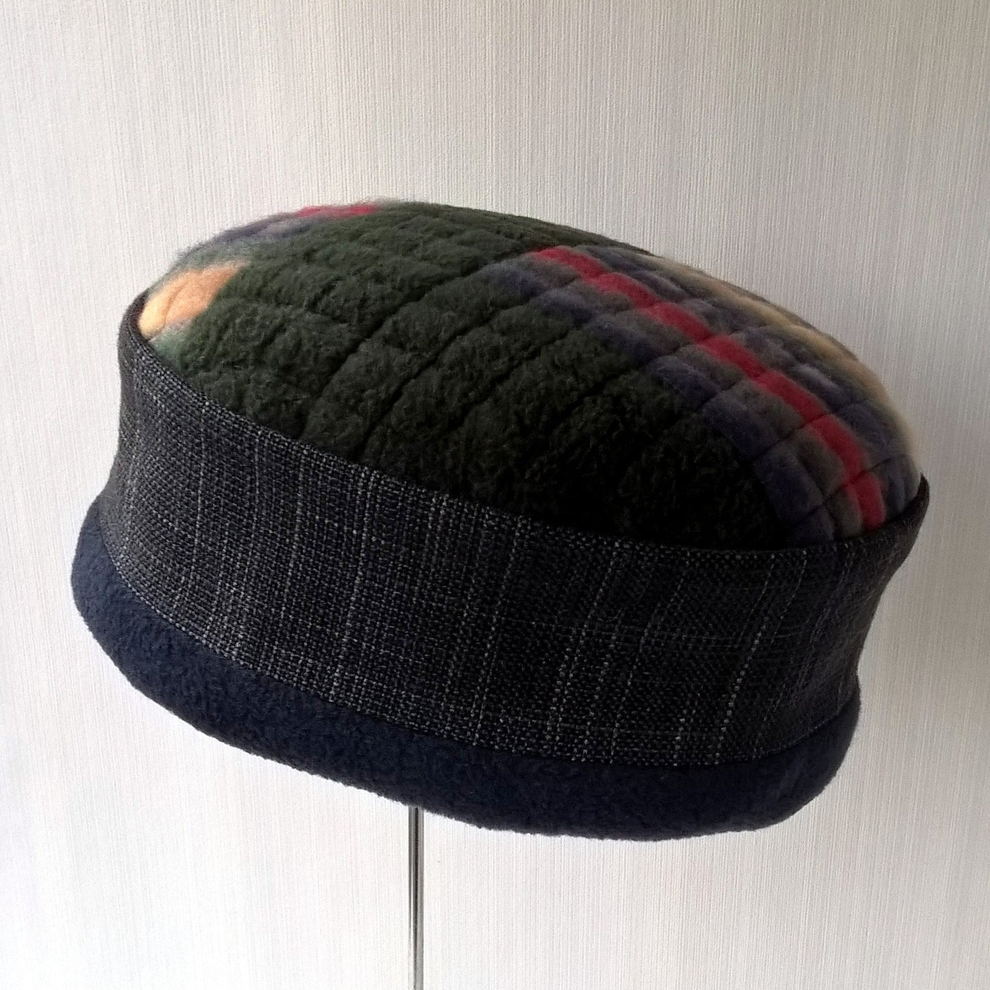 Pillbox shaped hat with multi coloured fleece tip and fleece lining